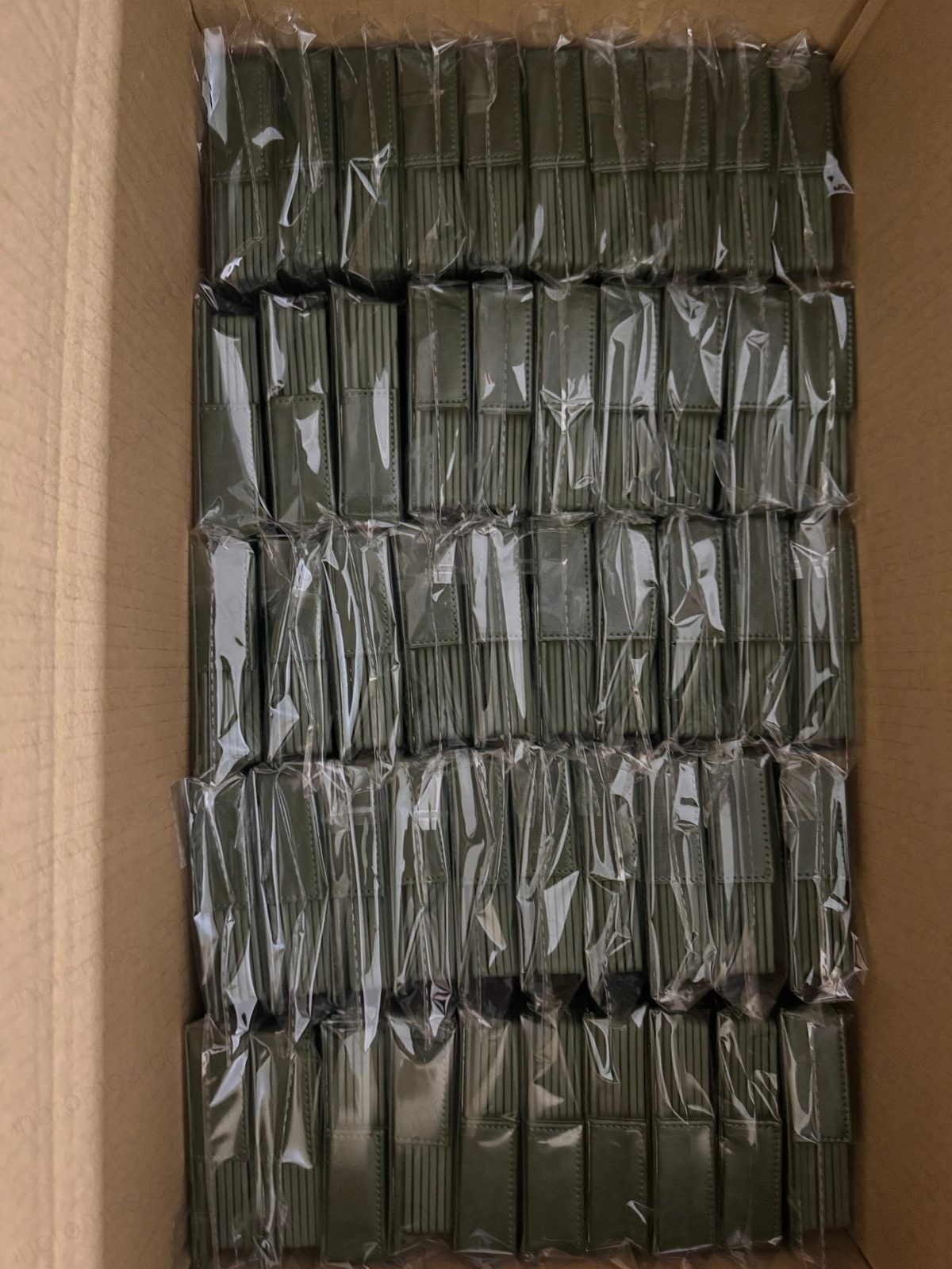 Open carton showing coasters individually wrapped in polybags — quality control photo
