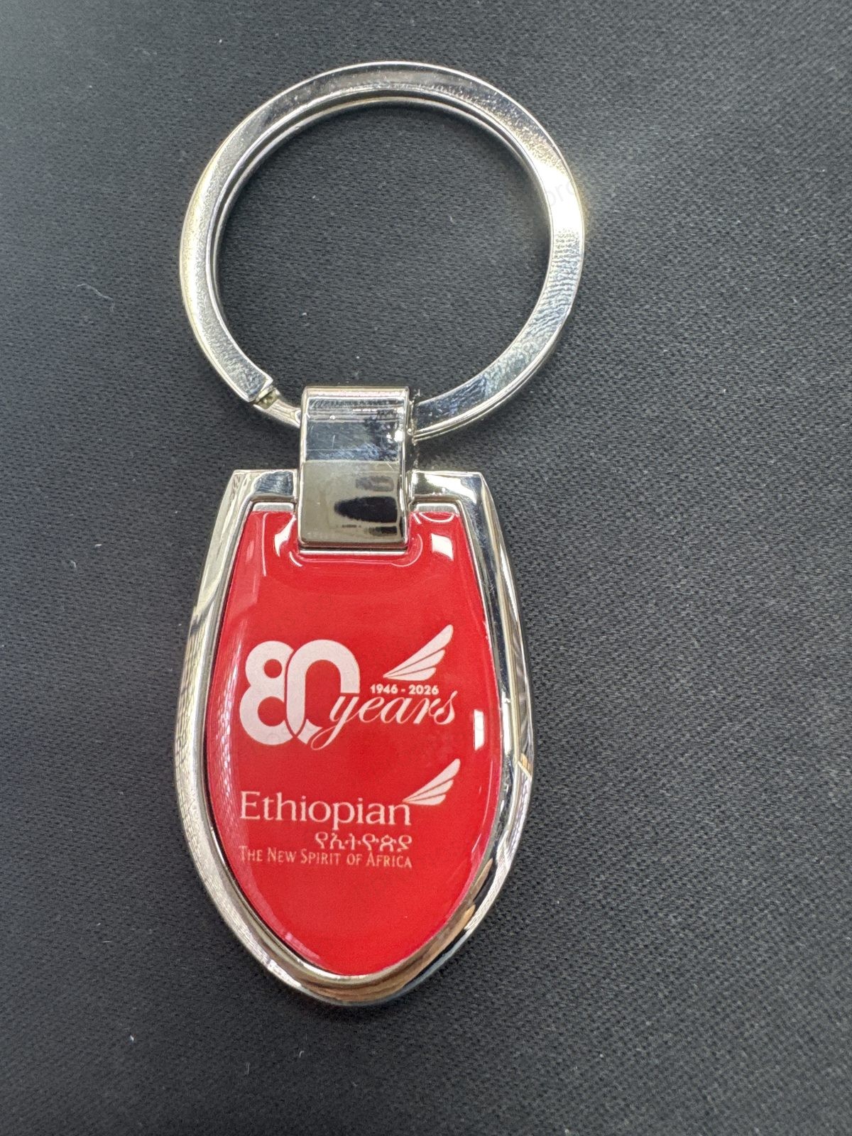 Metal keychain with 80th anniversary logo — production photo